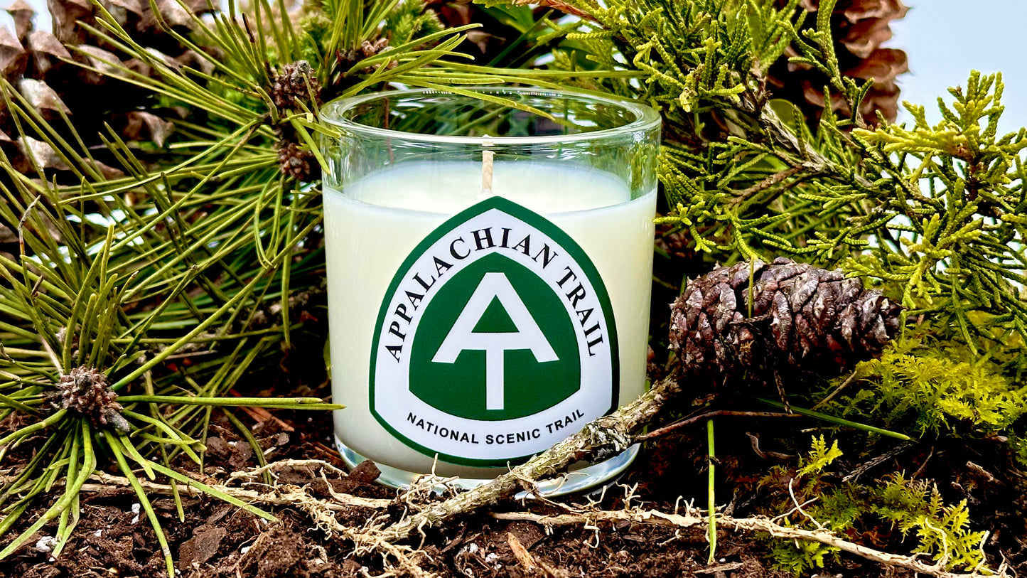 Appalachian Trail candle surrounded by forest greenery