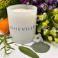 ASHEVILLE Signature Luxury Candle surrounded by flowers orange and herbs